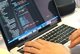 Das Bild zeigt zwei Hände bei der Eingabe am Laptop