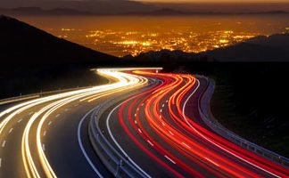 Das Bild zeigt eine Autobahn mit roten Rücklichtern in die eine und mit weißem Scheinwerferlicht in die andere Richtung
