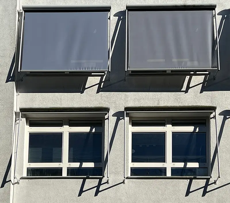 vit villa med markiser för fönstren