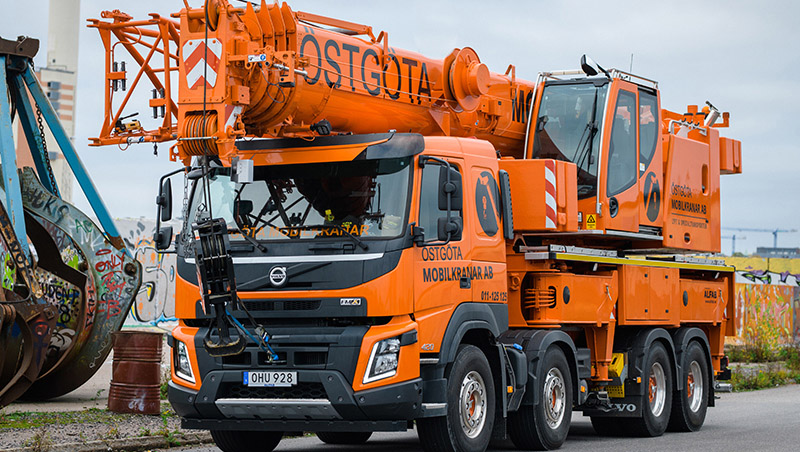 Orange mobilkran med företagstryck.