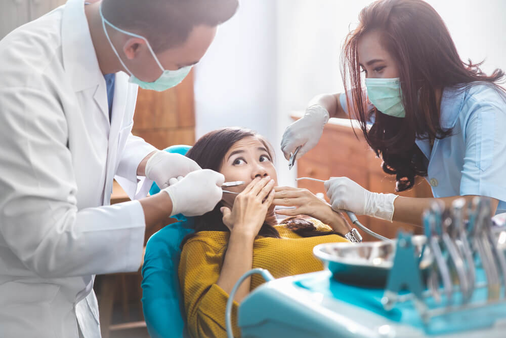 kvinna med ont i tandläkarstolen